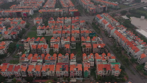 foggy,smoggy early morning drone footage flying backwards over urban high-rise and villa housing developments in district seven saigon, ho chi minh city, vietnam