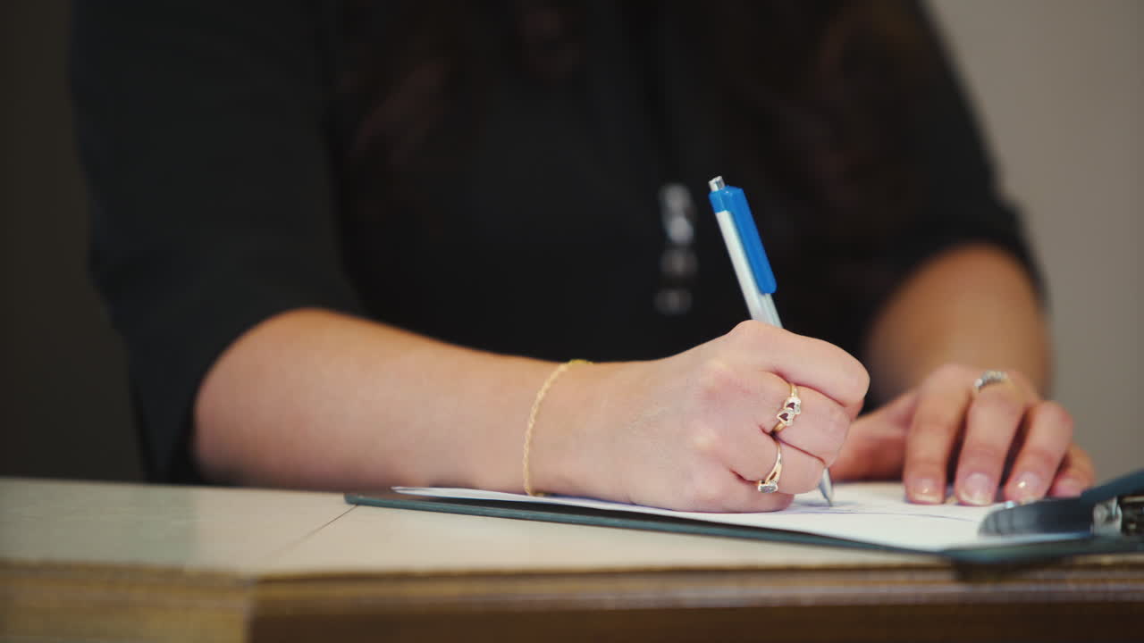 Secretary writing on a clipboard at her desk