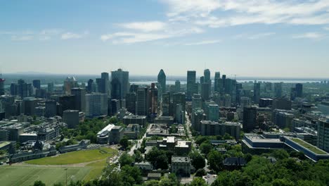 4K-Cinematic-urban-drone-footage-of-an-aerial-view-of-buildings-and-skyscrapers-in-the-middle-of-downtown-Montreal,-Quebec-on-a-sunny-day