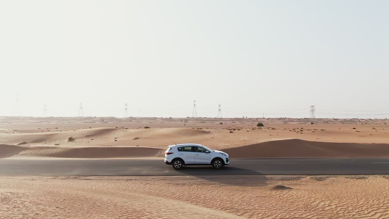 coche blanco conduciendo a través del desierto