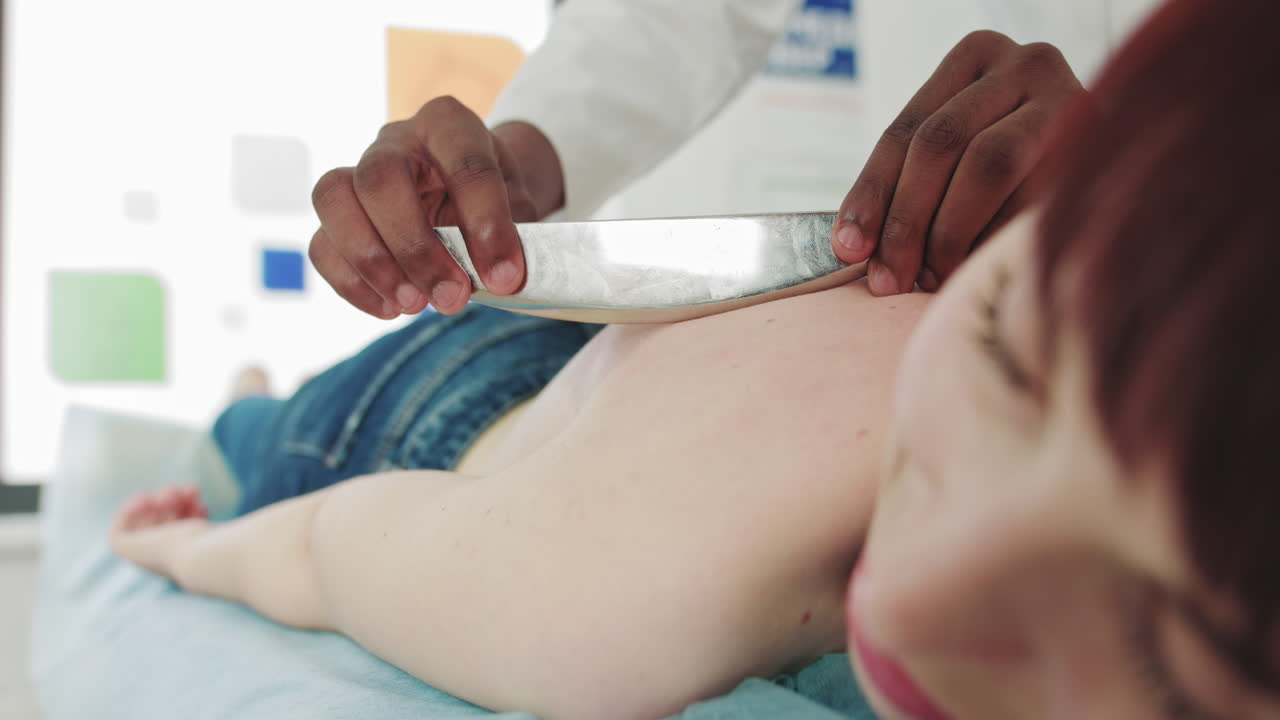 Rehabilitation concept rehabilitation african physiotherapist conducts massage therapy to young