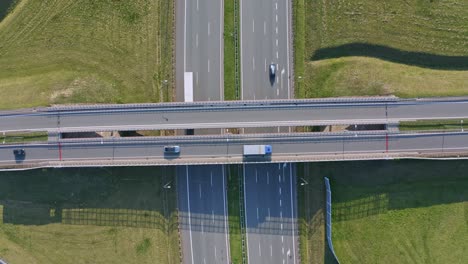 aerial top down view vehicles driving across icelandic multi level highway overpass infrastructure