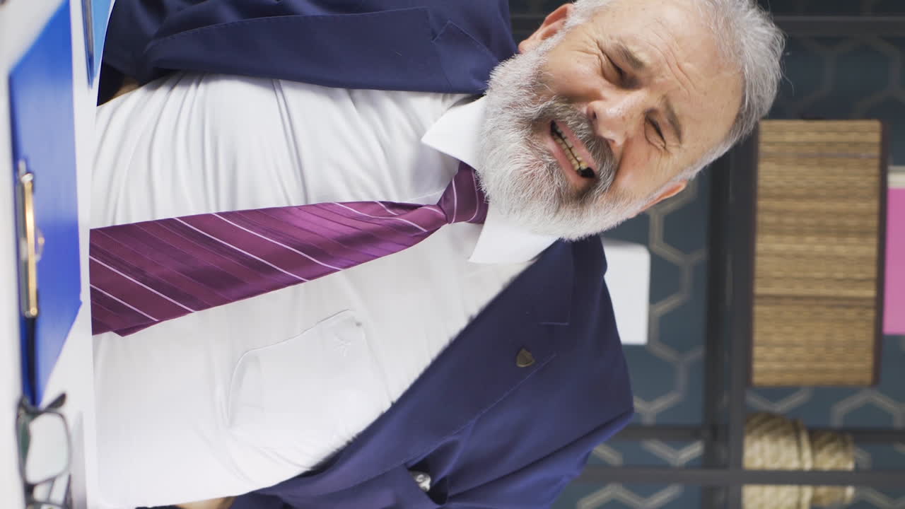 vídeo vertical de un viejo hombre de negocios con dolor de espalda. hernia.