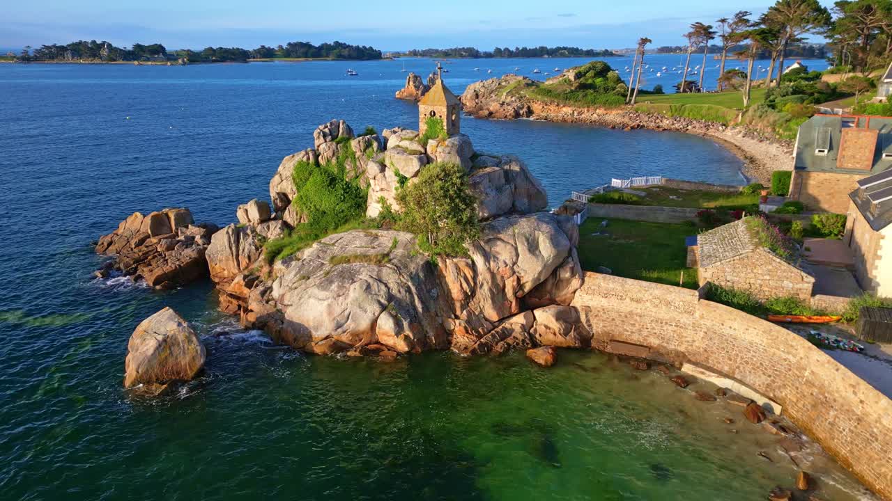 Rocher de la Sentinelle rock chapel Port-Blanc, Brittany France. Aerial drone backward