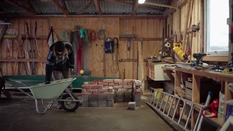 The-Man-is-Loading-the-Bricks-Into-the-Wheelbarrow-for-Use-in-the-DIY-Hot-Tub---Static-Shot