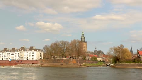 Gesichtsbewegung-Im-Zeitraffer-Von-Vergnügungsbooten-Und-Verkehr-Entlang-Und-Auf-Dem-Stadtbildboulevard-Von-Zutphen-Mit-Der-Dahinter-Aufragenden-Walburgiskerk-kathedrale-Und-Der-Verstärkten-Mauer-Im-Vordergrund