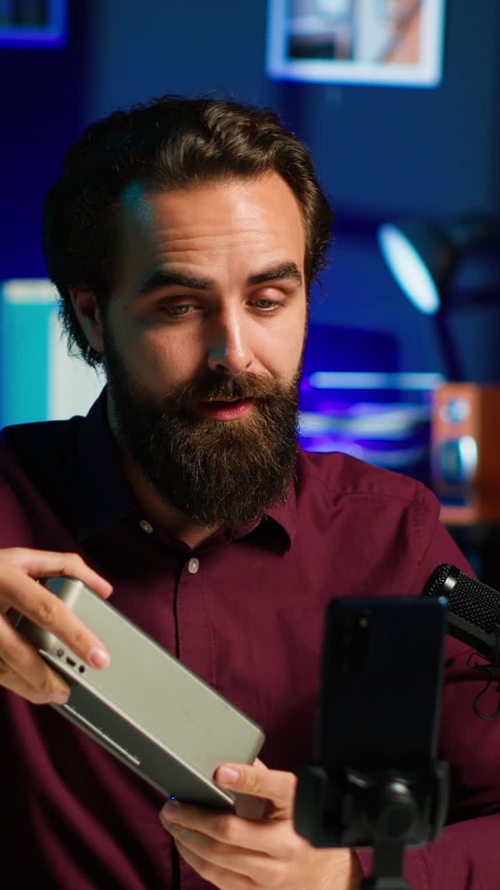 Video verticale di un influencer che mostra un dispositivo di riproduzione musicale e registra con uno smartphone