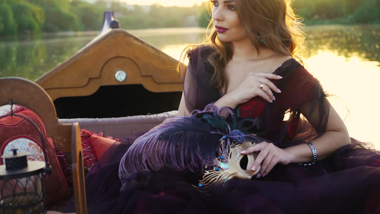 ?oung woman in a red dress in a boat on the river. Woman riding on gondola