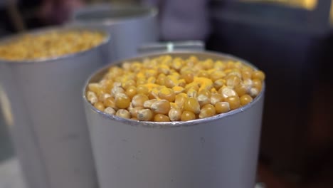 metal cups filled with corn stand on a counter