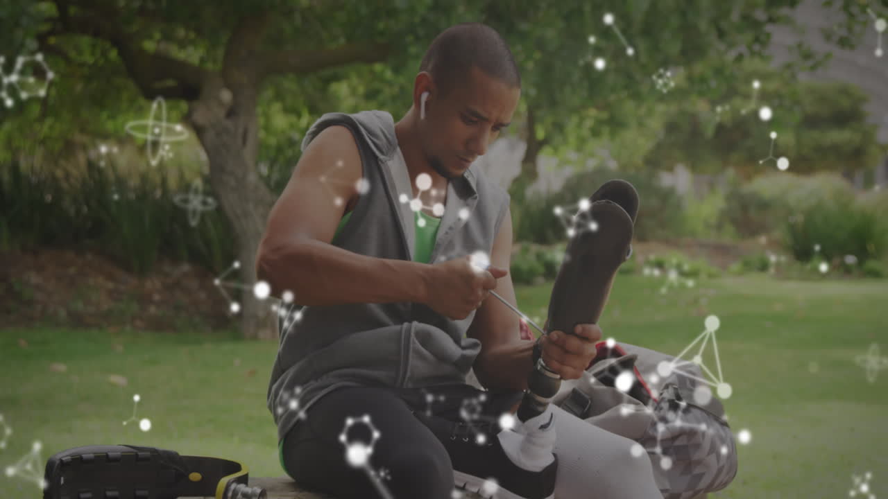Animation of communication networks over disabled male athlete adjusting prosthetic leg outdoors