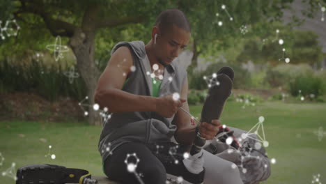 animation of communication networks over disabled male athlete adjusting prosthetic leg outdoors