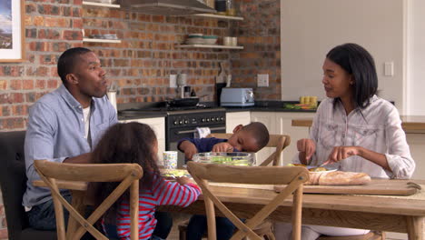 family eating meal in open plan kitchen together