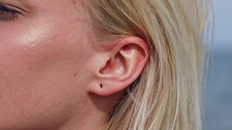 close up shot of wound hole in ear lobe of blonde woman,macro view