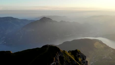 Vuelo-Aéreo-Alrededor-De-La-Cumbre-De-Niederbauen-Chulm-En-Una-Mañana-Dorada-De-Verano-En-Los-Alpes-Suizos-Con-Vistas-A-Mythen,-Rigi,-Burgenstock,-Pilatus-Y-Acantilados-Sobre-El-Lago-De-Lucerna