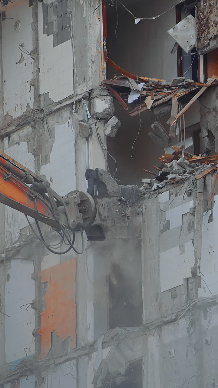 Demolition building by machine. Destruction excavator house demolishing. Vertical video
