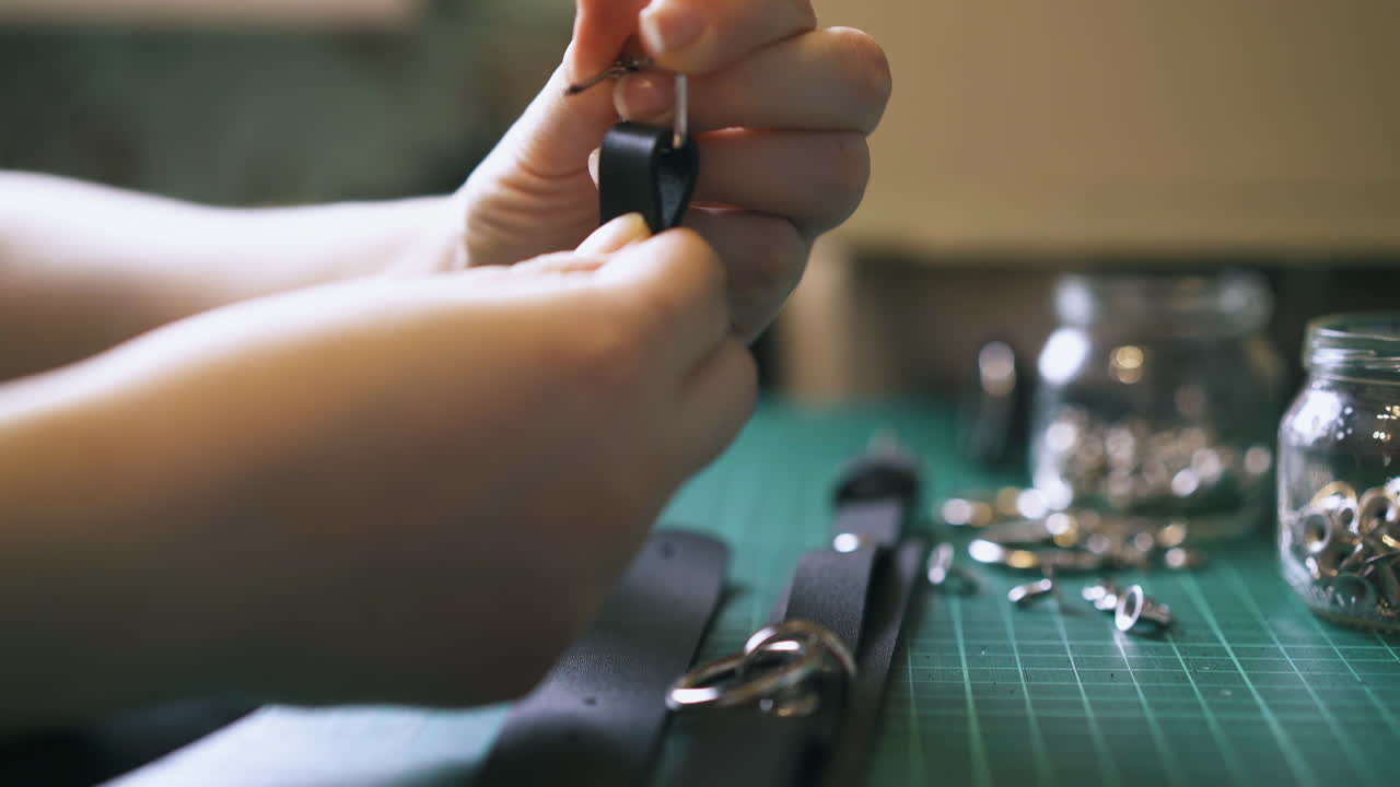 persona experta clava la hebilla de plata en la garganta de cuero negro