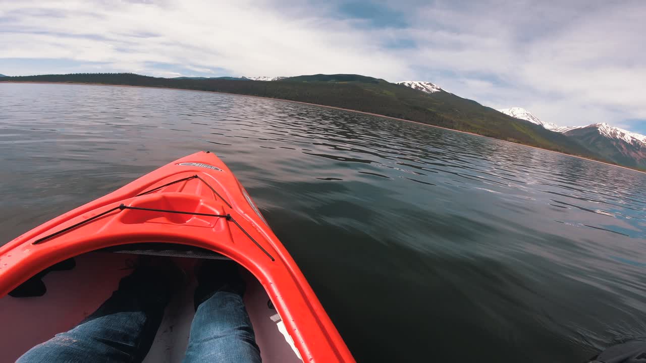 kayak en un pintoresco lago colorado rodeado por una cadena montañosa rocosa