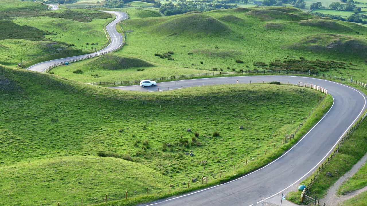 Zoom in shot of two cars driving up the infamous Snake Pass in the heart of Derbyshire Peak District
