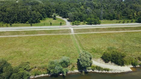 aerial - clear sava river reflects trees and distant skyline of zagreb croatia on summer day