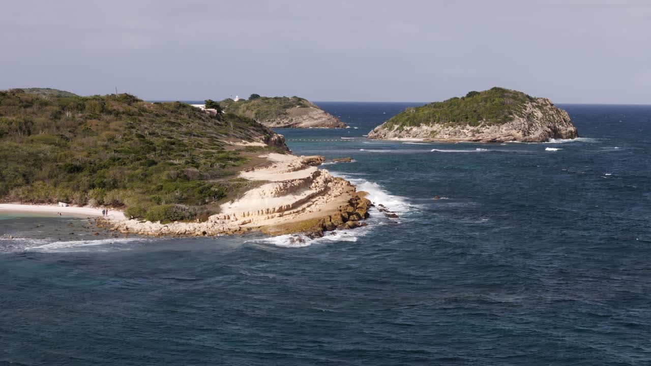Half Moon Bay Beach with turquoise waves crashing on rugged shoreline in Antigua, sunny day