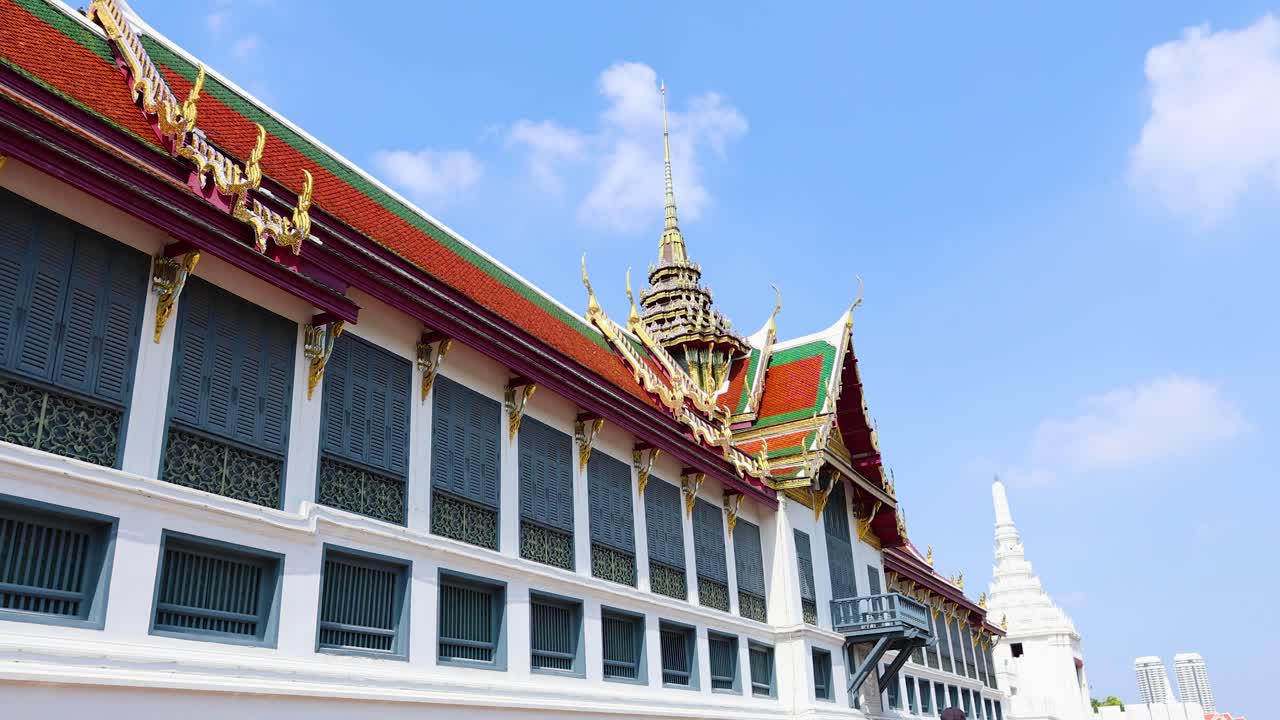A dynamic view of the Temple of the Emerald Buddha in Bangkok, showcasing its intricate architecture under clear blue skies
