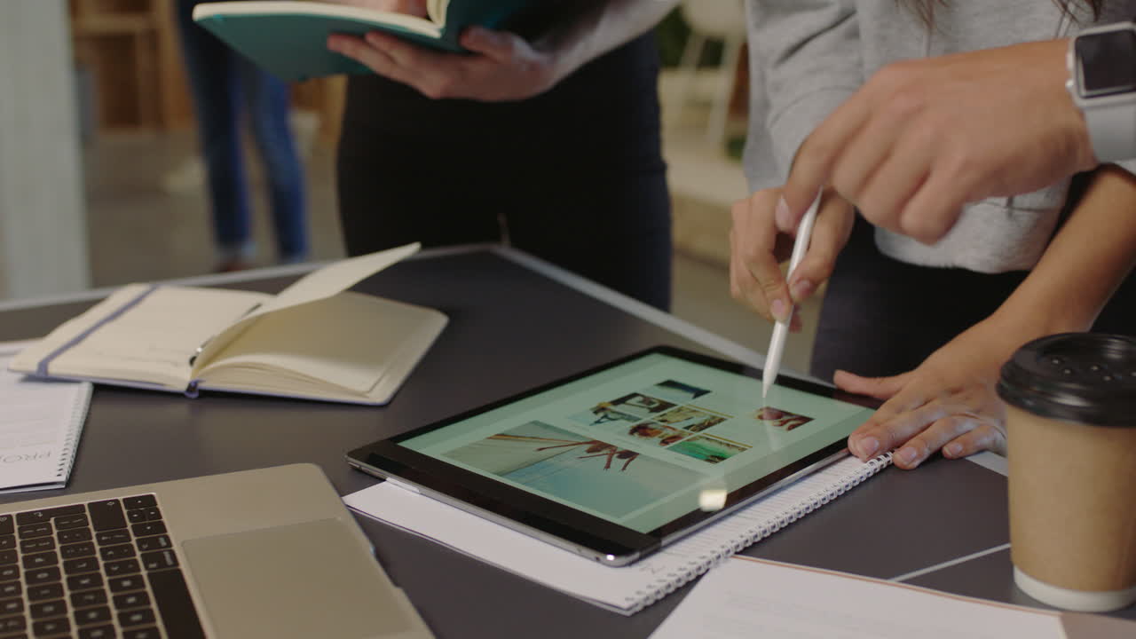 young diverse business people brainstorming graphic design team using tablet computer designing website layout sharing ideas working together on creative project in trendy office