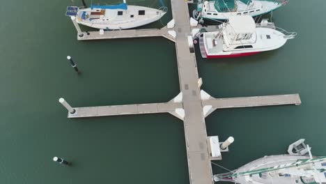 Topdown-view-along-marina-pier,-boats-moored-in-Ko-Olina,-Hawaii