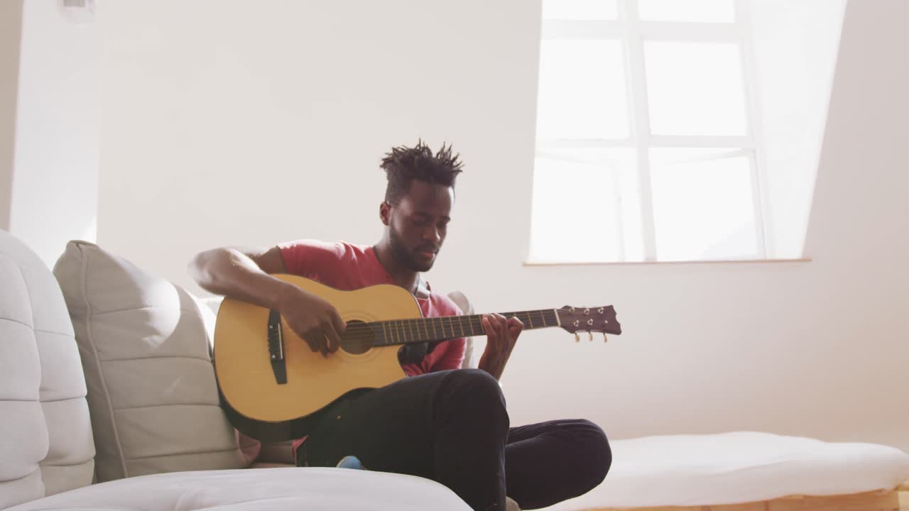 Mand spiller guitar derhjemme