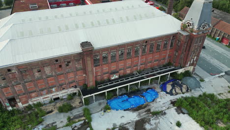 forward tilt to overhead aerial of an old abandoned brick building in ghent