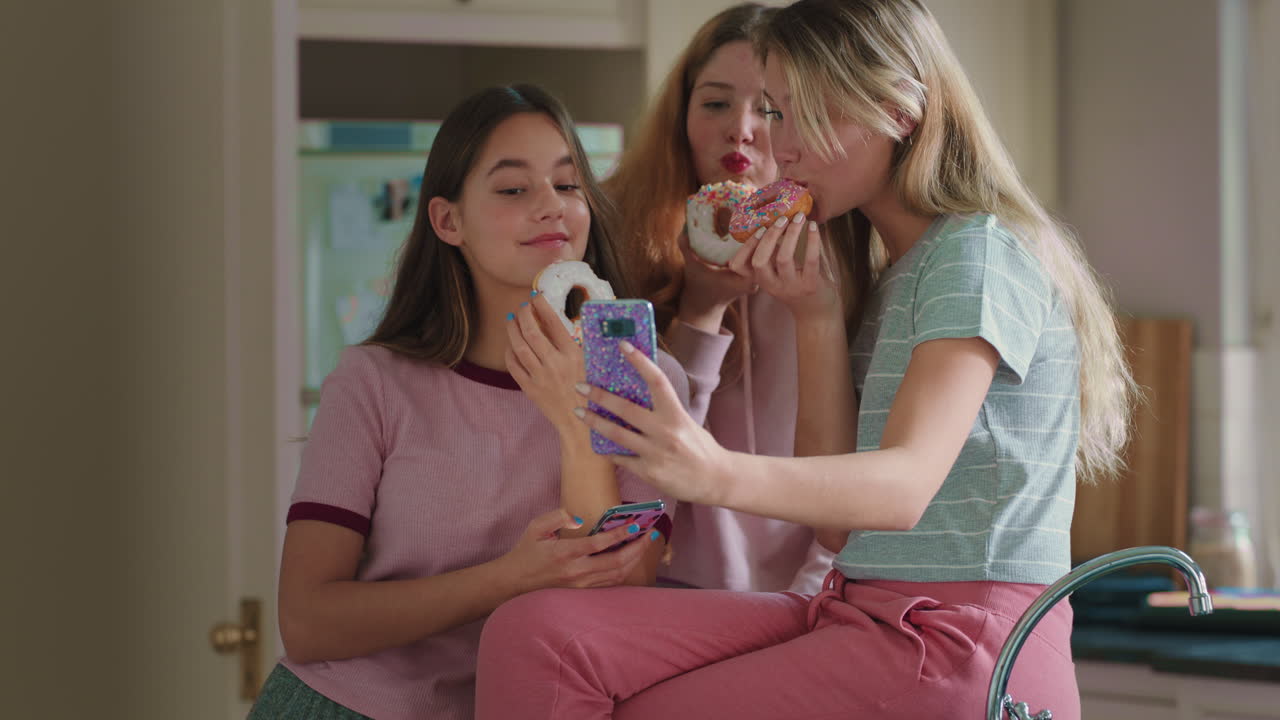 재미있는 십대 소녀들이 도 ⁇ 과 포즈를 취하고 스마트폰을 사용하여 사진을 찍고 소셜 미디어에서 공유하고 주말에 부 ⁇ 에서 어울리는 것을 즐기고 있습니다.