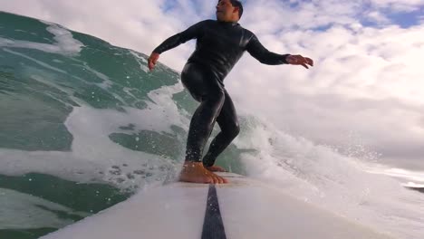 goofy surfer riding blue wave doing a good reentrie on the end at slow motion mode, sintra 2022