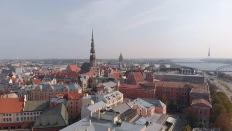 Drone-aerial-view-of-Riga-skyline-in-Latvia-looking-across-the-Daugava-River-and-city,-and-the-Riga-Radio-and-TV-Tower