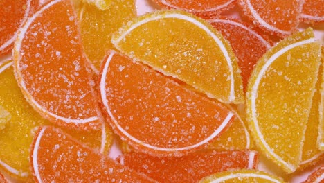 tasty orange gummy marmalade fruit jelly, sprinkled with sugar candies, rotate slowly.