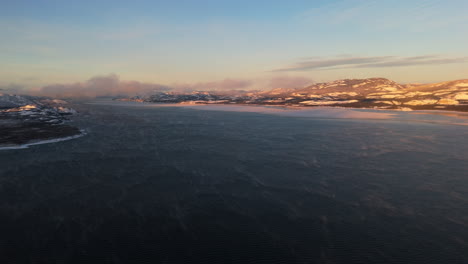 sunset over laberge lake in yukon, canada in winter - drone shot