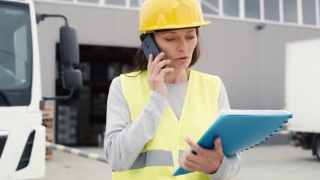 Caucasian-woman-in-front-of-warehouse-talking-by-mobile-phone.