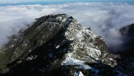 aerial shot of the mountain pico ruivo in madeira with thin clouds in the background