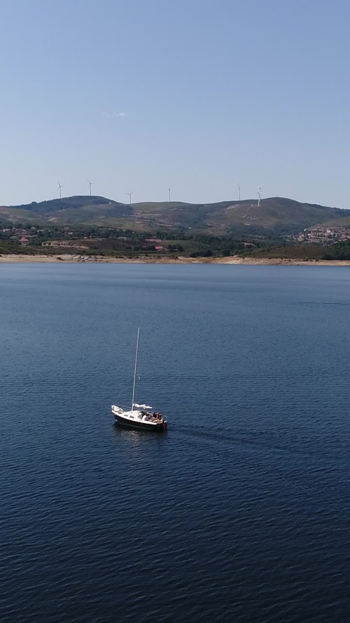 Barca in un lago blu e cielo blu - Video verticale.