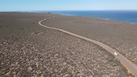 Antena-De-Drones-Avanzando-Con-Una-Camioneta-En-La-Carretera-Junto-Al-Océano-Australiano