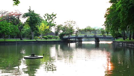 boat on lake with bridge and trees