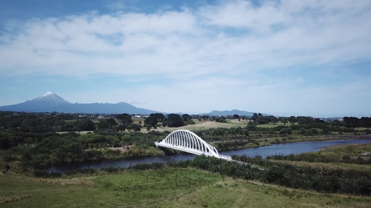 Scenic Aerial View of a Bridge over a River with a Mountain in the Background