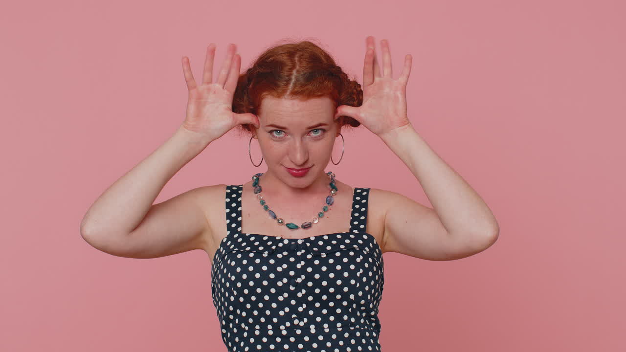 Redhead woman showing tongue making faces at camera, fooling around, joking, aping with silly face