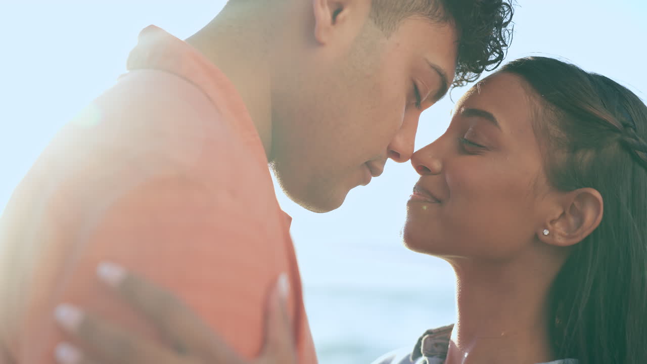 Love, smile and kiss with couple at beach