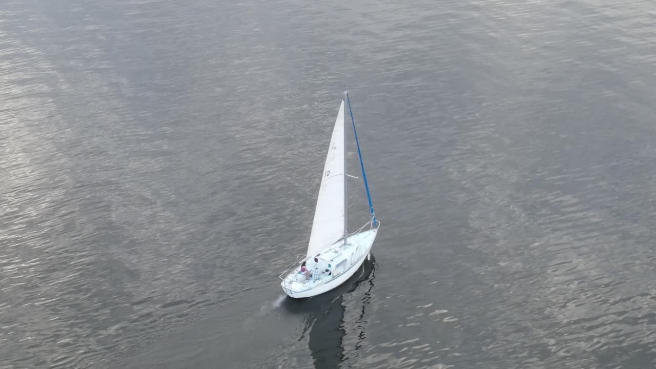 velero en medio del océano con reflejos en el agua - toma aérea de drones