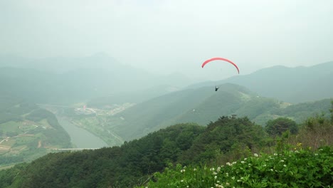 one tandem paraglider after took off from the mountain peak in danyang, south korea