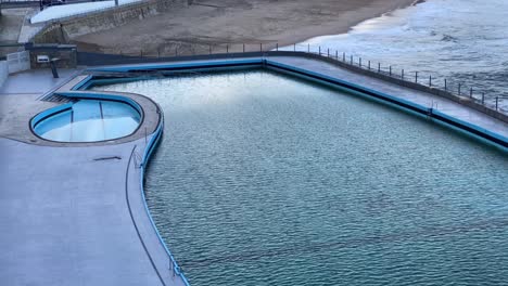 swimming pool near the beach with some small waves crashing