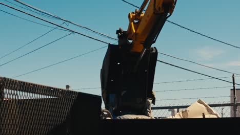 excavator bucket poised against a clear sky for operation