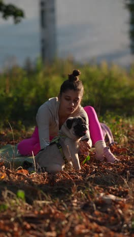 mujer y perro pug relajándose al aire libre