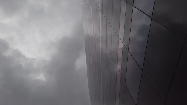 Dark, cloudy sky reflected in a dark glass building