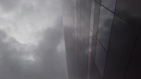 dark, cloudy sky reflected in a dark glass building