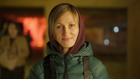 portrait of a lovely smiling blonde woman in a hood on a street background. natural beauty